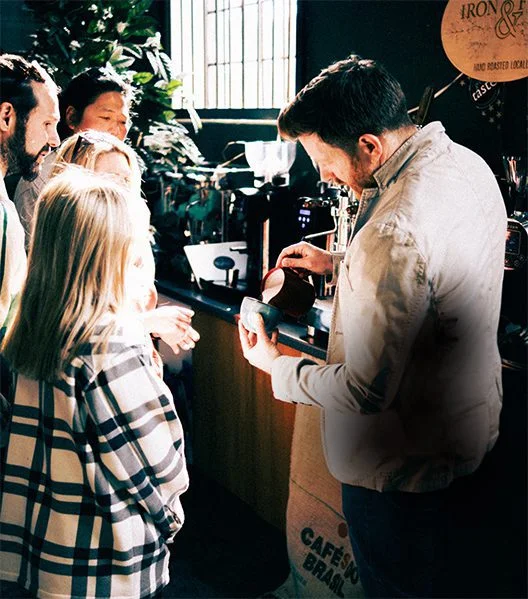 An image of a wholesale barista training a new coffee employee.