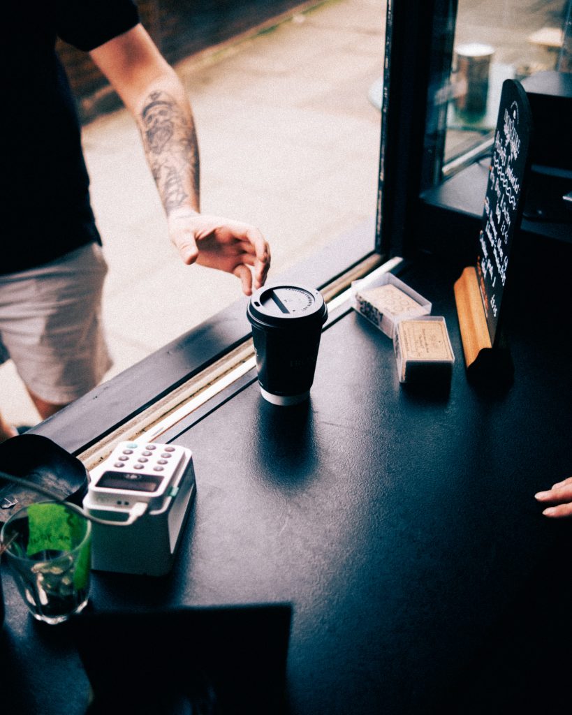 image of serving window with cup of coffee being passed throug