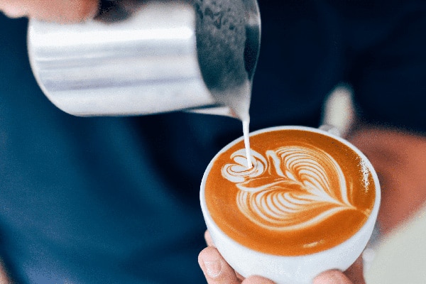 An image of a cup under a coffee machine.