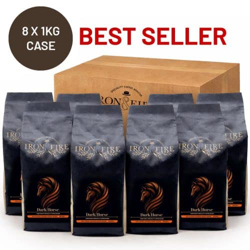 8 black bags of coffee standing with a cardboard box behind them